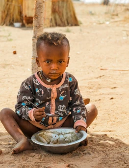 African boy with a bowl of food