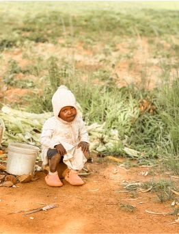 African child sitting in a field